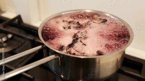 Close up of dyeing Easter eggs using natural hibiscus tea to create a deep blue marbled texture, eco-friendly DIY holiday traditions. Dyeing eggs with hibiscus creates stunning, natural shades.