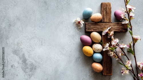 Easter cross with pastel eggs and cherry blossoms on a concrete background for spring celebration