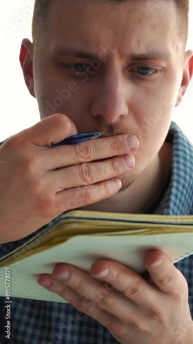 A student in a blue shirt studies and takes notes in a notebook.
Listening to material at the university.