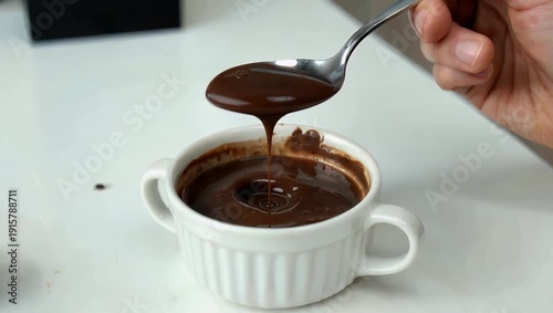 Cinematic 4K close up of spoon taking creamy chocolate pudding from bowl on white table highlighting texture motion appetizing dessert presentation culinary food stock 