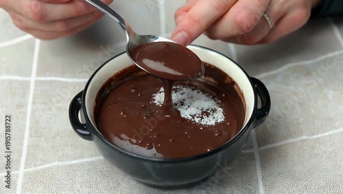 High resolution 4K close up of spoon scooping chocolate pudding from bowl on light table emphasizing smooth texture motion rich dessert appeal culinary stock 