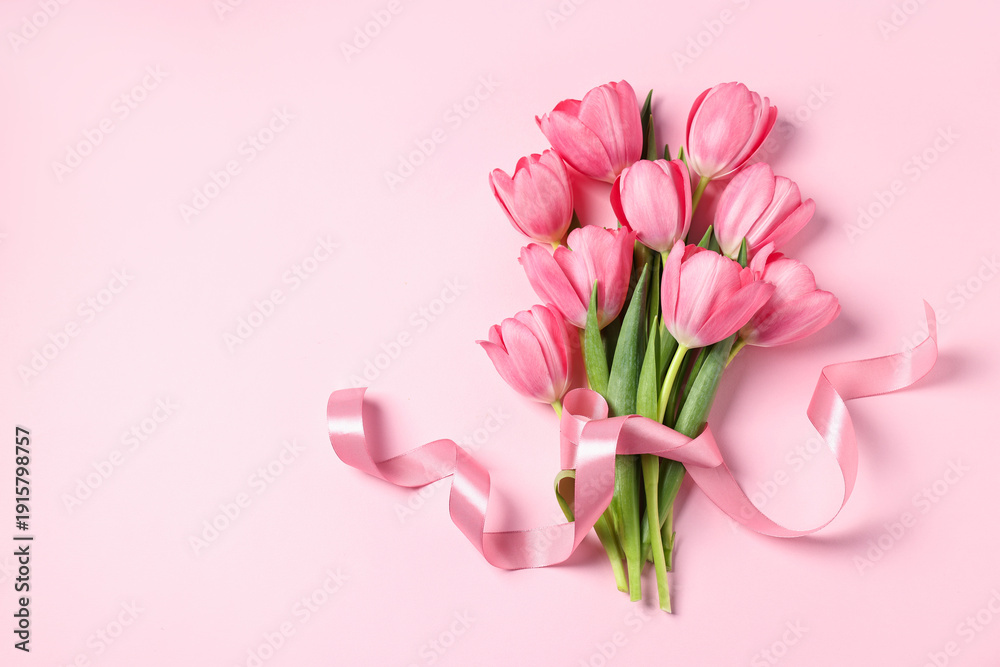 Fototapeta premium Bouquet of tulips on pink background, top view. Space for text