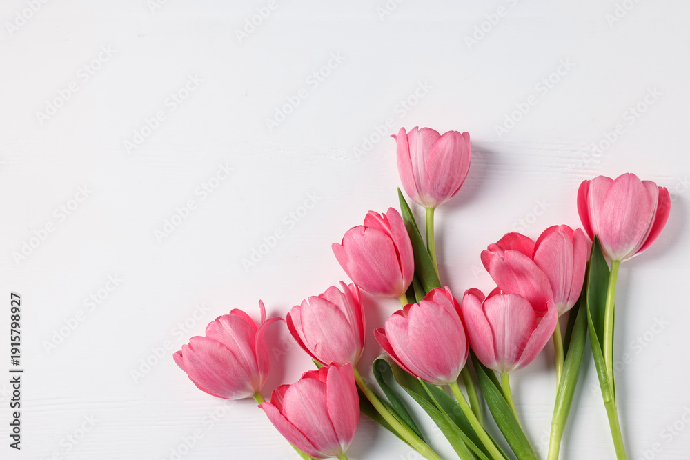 Obraz premium Beautiful pink tulips on white table, flat lay. Space for text