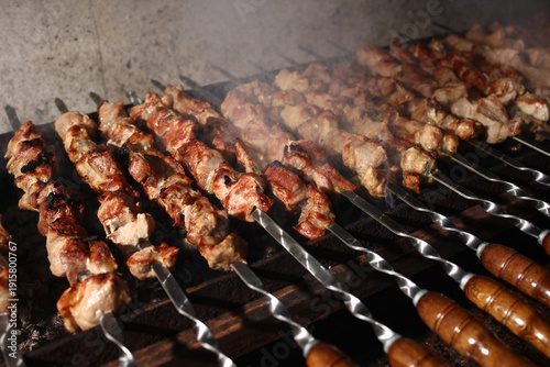 Juicy grilled shashlik kebab on skewers cooking over hot coals