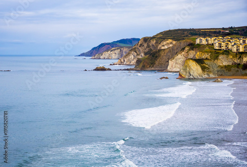 Rocky coastline and sandy beach with cliffs and ocean waves. High quality photo