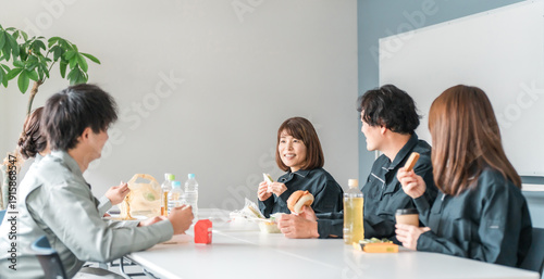 Businessmen and women in work clothes eating lunch in the break room