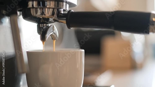 Espresso machine pouring fresh hot coffee into a white cup with steam rising in a bright kitchen