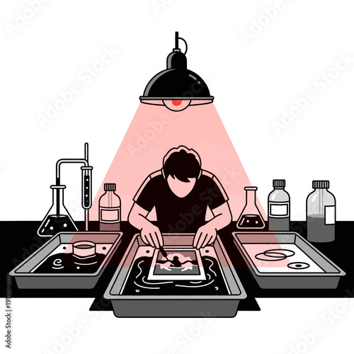 Illustration of a person developing film in a darkroom with trays and a red safety light