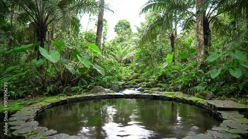 A serene circular stone pond nestled deep within a vibrant lush tropical jungle surrounded by dense green foliage ferns and tall trees creating a peaceful and ancient natural sanctuary with reflectio.