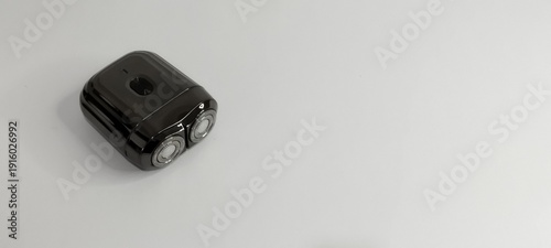 electric shaver on a white table positioned on the left side of the photo