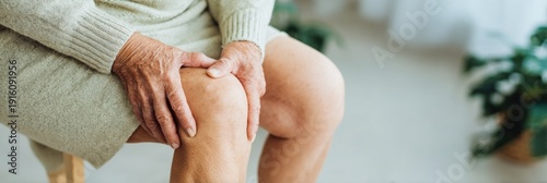 Elderly woman holding aching knee joint during physical therapy at home, senior patient experiencing chronic leg pain for geriatric healthcare and medical service advertising