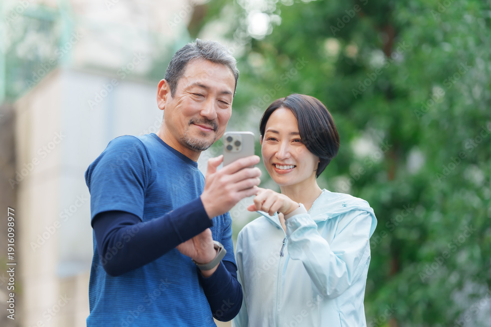 Fototapeta premium 運動をする男女 スマートデバイス