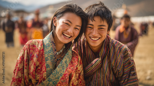 Young Bhutanese couple smiling together during Tangsibi Mani Festival in a sunny outdoor setting with traditional clothing and joyful expressions