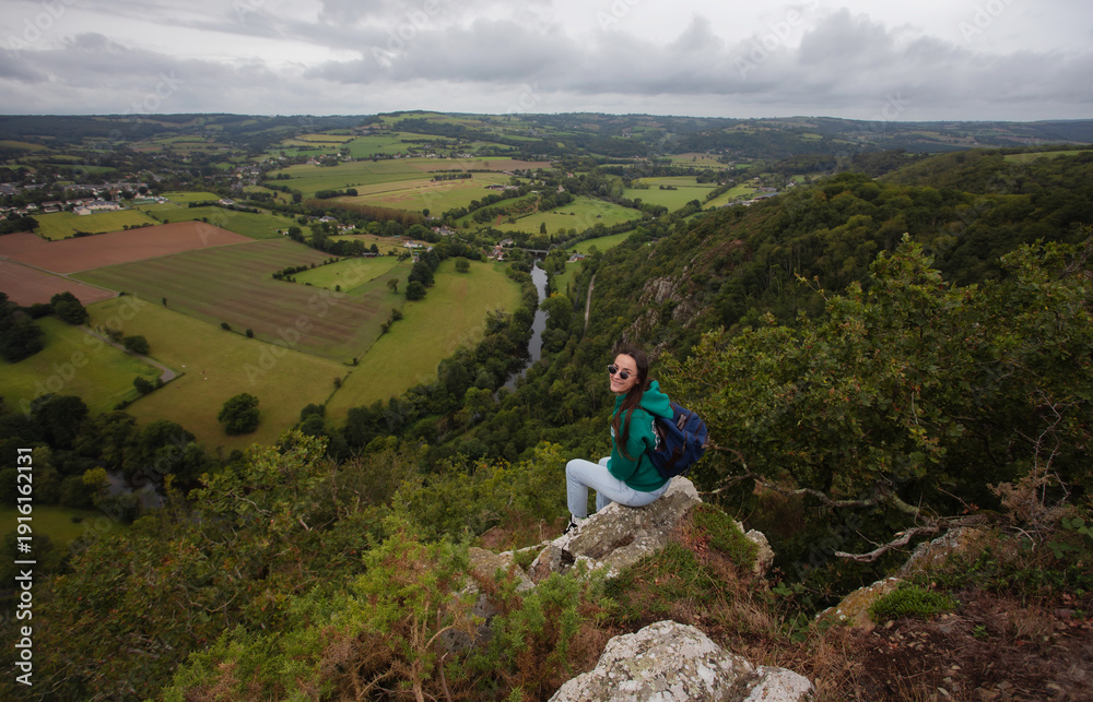 Obraz premium Wide panoramic view of a countryside valley with fields, forest and river under a cloudy sky, peaceful rural landscape and travel concept.