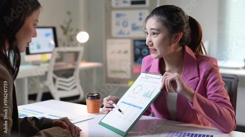 Businesswomen analyzing financial data in modern office