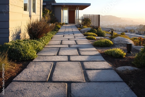 Front entry path featuring textured concrete pavers and a neutral house exterior