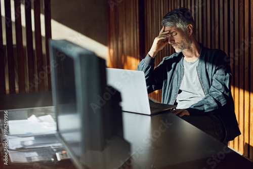 Casual businessman sitting in his sustainable office, had in hand