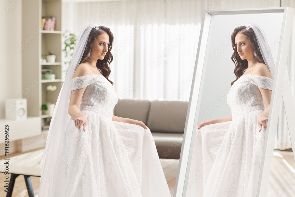 Fototapeta premium Bride trying a wedding dress in front of a mirror