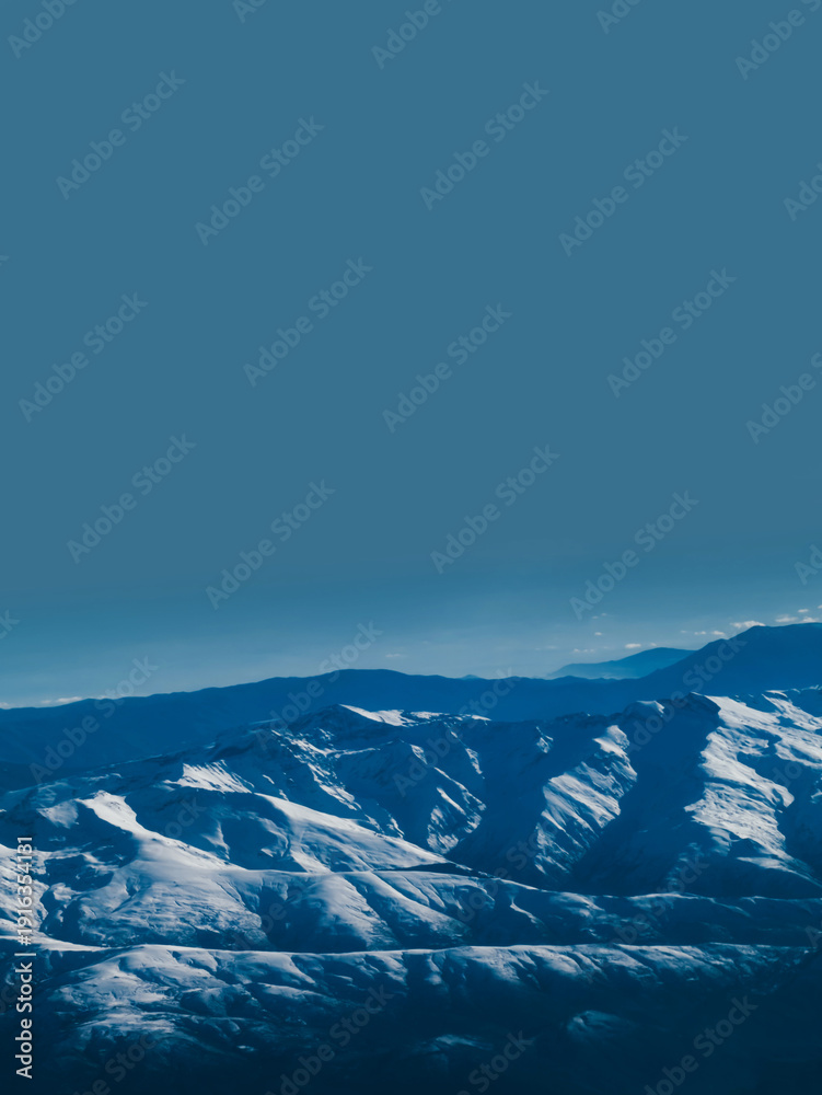 Fototapeta premium Snow Covered Mountain Range Above Horizon