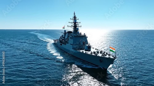 A powerful Indian Navy destroyer cuts through the vast blue ocean, leaving a white wake under a clear sky, symbolizing strength and maritime defense