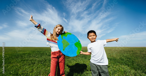 Cuadro en lienzo Kids hold globe outdoors for world awareness