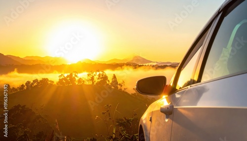 A stunning sunset viewed from a parked car, with mountains and mist in the background