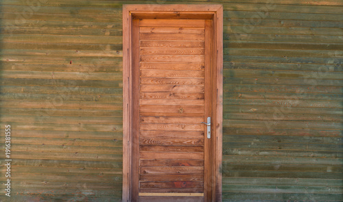 The entrance door of the wooden cabin. A modern miniature wooden house.
