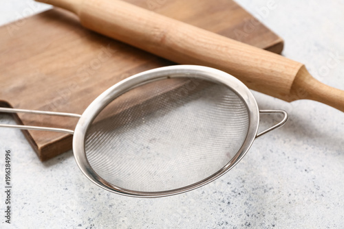 Metal sieve, wooden board a...