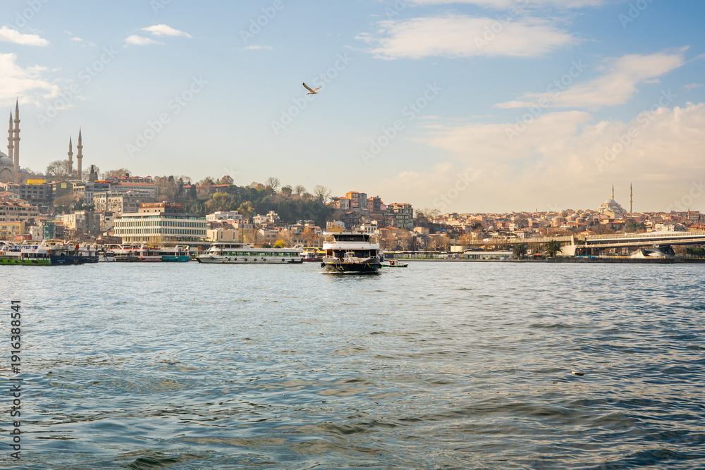 Fototapeta premium Ferries crossing Golden Horn with mosque skyline
