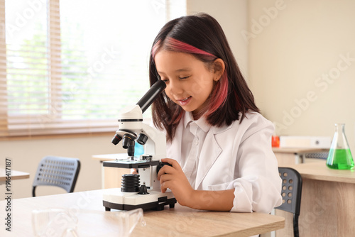 Cute little girl using micr...