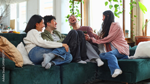 Canvas Print Friends laughing together, enjoying time on sofa at home