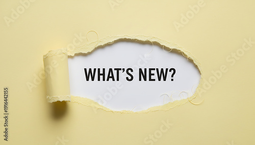 Torn yellow paper reveals text what's new torn paper