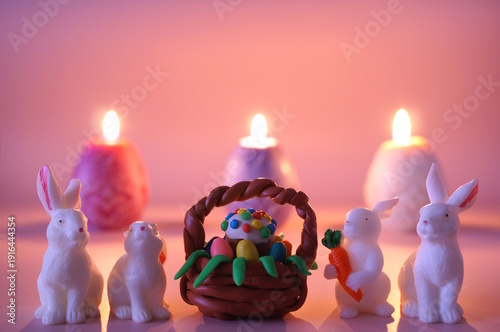 Wallpaper Mural Toy rabbits and a basket with an Easter cake on a pink colored background. There are burning candles in the background. Torontodigital.ca