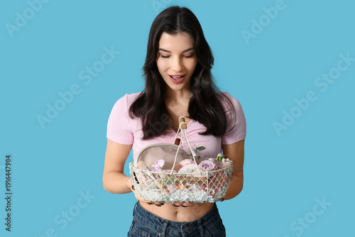 Surprised young woman holdi...