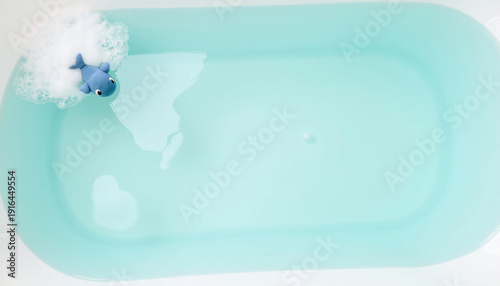 Toy shark floating in bathtub with light blue water background  