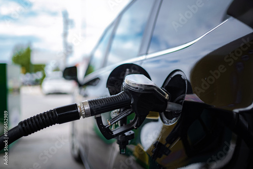 Wallpaper Mural Fuel pump nozzle refilling a car with petrol at a service station Torontodigital.ca