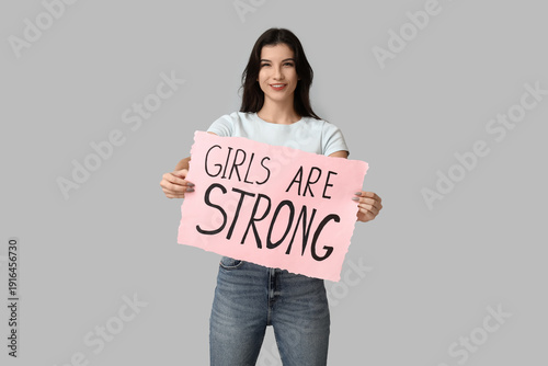 Young woman holding sign wi...