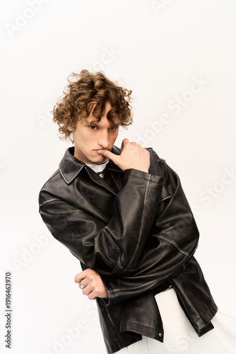 Stylish young man poses confidently in trendy outfit with a modern flair