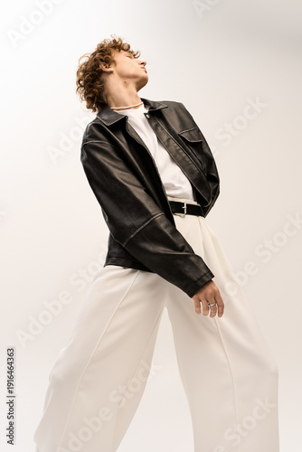 Stylish young man showcasing modern fashion in a minimalist studio setting