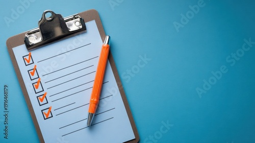 Blank checklist on a clipboard with orange pen resting nearby, showcasing organization and productivity for personal or professional tasks in a bright setting