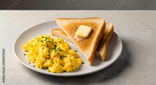 A plate of scrambled eggs and toast on a table