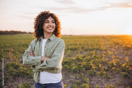 Foto Young agronomist woman enjoying sunset in soybean field