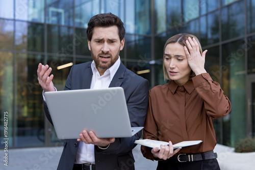 фотографія Business partners experiencing shock and concern after discovering a mistake or