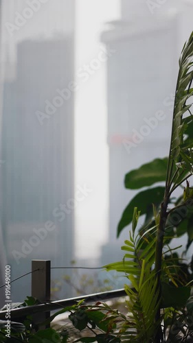 Heavy rain pouring over city skyscrapers and wet streets, Downpour drenching urban highrises, moody rain atmosphere, 4k vertical video