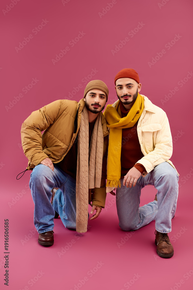 Obraz premium Stylish twin brothers posing together with confidence in a vibrant setting
