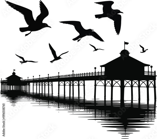 A long Victorian seaside pier reflects in the calm water as seagulls fly around its structures.