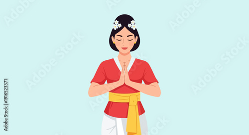 Balinese woman in traditional attire offering prayer with hands clasped.