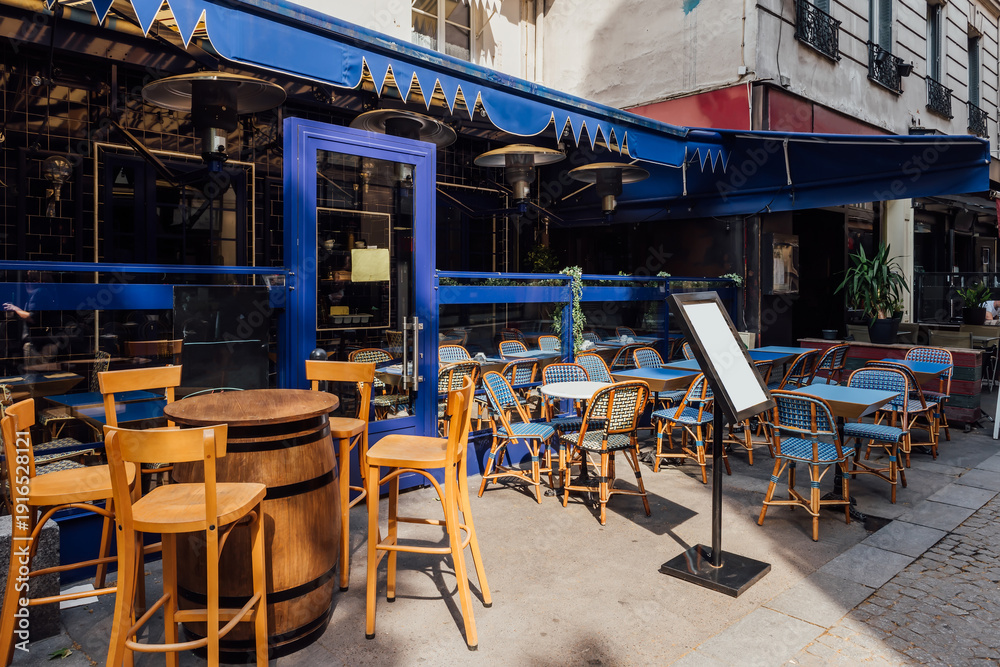 Fototapeta premium Cozy street with tables of cafe in Paris, France. Architecture and landmark of Paris. Cozy Paris cityscape.