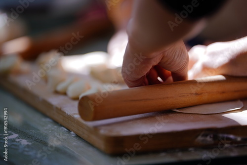 Foto A skilled hand shapes translucent dough into dumplings on a rustic