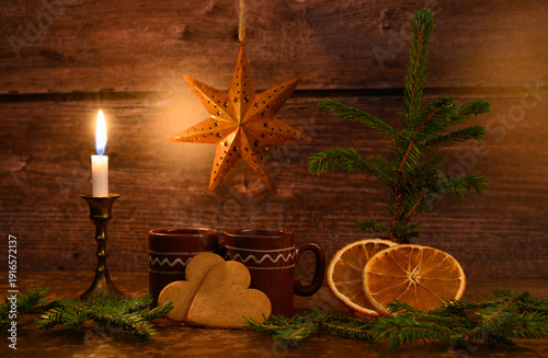 Mulled Wine and Gingerbreads surrounded by lit up candle and pine tree.